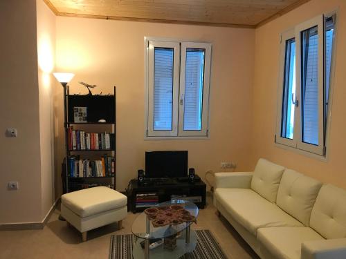 un soggiorno con divano bianco e finestre di Eugenies Home a Áno Váltai