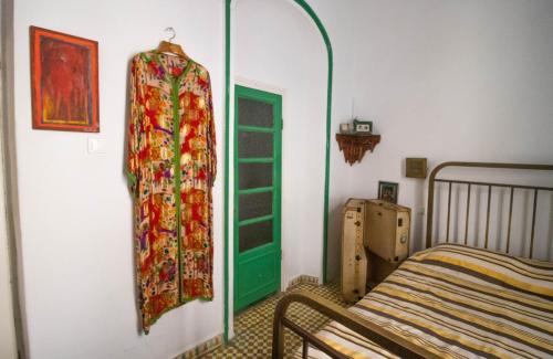 a bedroom with a bed and a curtain on the wall at Bayt Alice Hostel in Tangier