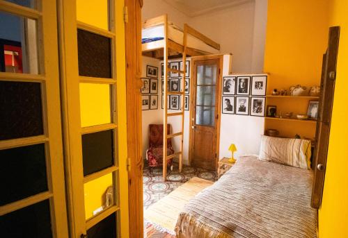 ein Schlafzimmer mit einem Bett in einem Zimmer mit gelben Wänden in der Unterkunft Bayt Alice Hostel in Tangier