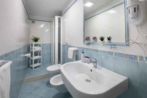 a bathroom with a sink and a toilet and a mirror at Sami Guest House in Sorrento