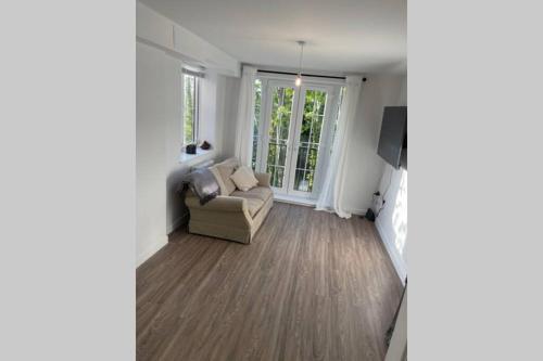 a living room with a couch and a tv at Croydon Gem Apartment - Fast train to the centre and free parking in Purley
