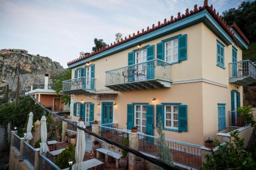 a house with blue shutters and a balcony at Acronafplia Pension A in Nafplio