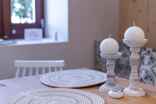 two white candles sitting on top of a table at Althea Apartments 2 in Halki