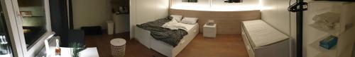a room with a bed and a table with a lamp at Cosy Novi Sad loft, self check-in in Petrovaradin