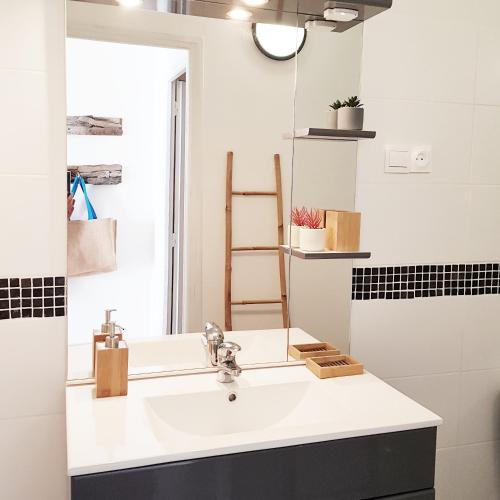 une salle de bain avec un lavabo et un miroir dans l'établissement Appartement T2bis Sartène 60m2 avec jolie terrasse de 25m2 et vue panoramique mer et montagne sur le Golfe du Valinco - Quartier calme à 10mn à pied du centre ville - Idéal pour 4 personnes et possibilité de 6 couchages - Place de parking réservée, à Sartène