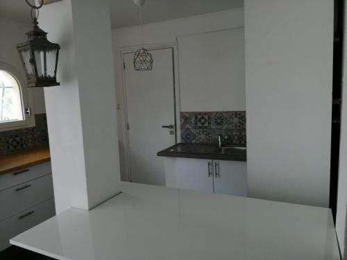 eine Küche mit einer weißen Theke und einem Waschbecken in der Unterkunft Loft 1 in La Trinité