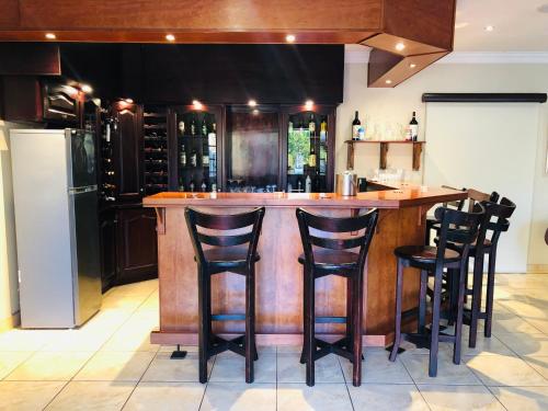 a bar with black stools in a kitchen at Wild Dog Guest Lodge in Hoedspruit