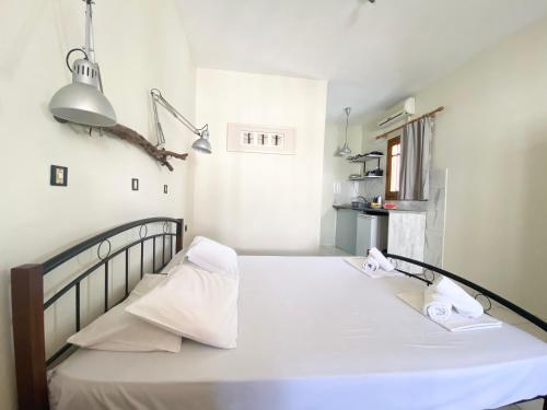 ein Schlafzimmer mit einem Bett mit weißen Laken und Handtüchern in der Unterkunft Egli in Stalós