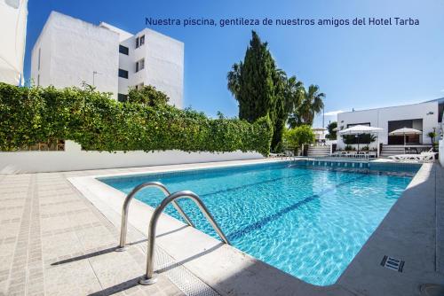 einem Pool vor einem Gebäude in der Unterkunft Hotel Marfil in Sant Antoni de Portmany