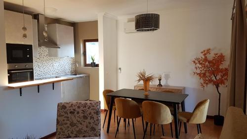 a kitchen and dining room with a table and chairs at Sobreiro Apartamentos in Rio Caldo