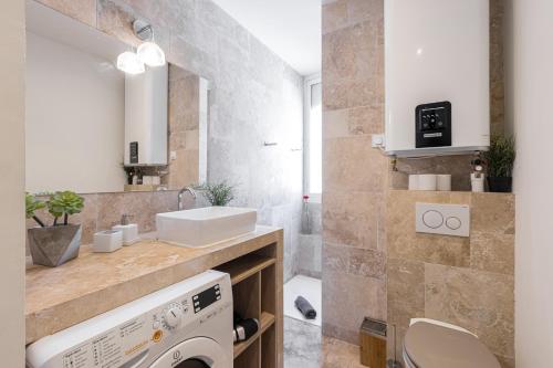 une salle de bain avec un lavabo et une machine à laver dans l'établissement FEEL HOME - ALPHONSE KARR, à Nice