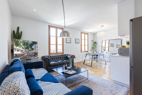 un salon avec un canapé bleu et une table dans l'établissement FEEL HOME - ALPHONSE KARR, à Nice