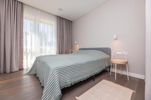 ein Schlafzimmer mit einem Bett mit einer schwarzen und weißen Decke in der Unterkunft Guesthouse Žilvičių g. 5 in Palanga