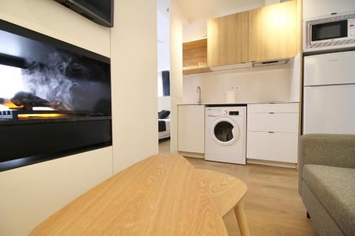 a kitchen with a washing machine and a living room at ESTUDIO PORT EXPERIENCE in Tarragona