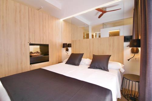 a bedroom with a large bed and a fireplace at ESTUDIO PORT EXPERIENCE in Tarragona