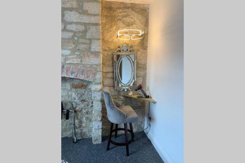 a bathroom with a chair and a mirror at The Rockpool - private hot tub and sea views in Amble