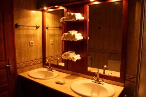 a bathroom with two sinks and a large mirror at Quinta do Carvalho - Nature Guest Houses in Guimarães