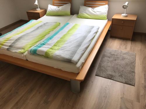 ein Bett mit einem Holzrahmen und einer Decke darauf in der Unterkunft Ferienwohnung Salzwedel in Salzwedel