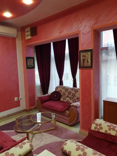 ein Wohnzimmer mit einem Sofa und einem Tisch in der Unterkunft Apartman Lazić No-2 in Gračanica
