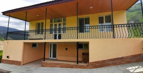 a large building with a balcony on top of it at Hotel Garbani in Stepantsminda