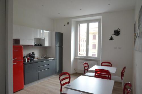 a kitchen with a red refrigerator and a table and chairs at SunnyCornerinRHome in Rome