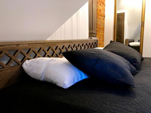 un lit avec deux oreillers dessus dans l'établissement Heritage House Nida with 2 Bedrooms & Free Parking, à Nido