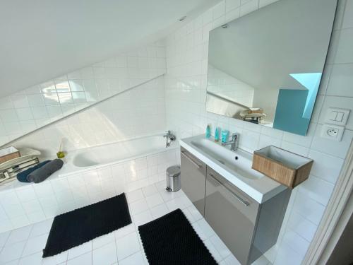 une salle de bain blanche avec une baignoire et un lavabo dans l'établissement Superbe LOFT centre-ville - Sauna - parking privé -Clim- 1 à 10personnes, à Brive-la-Gaillarde