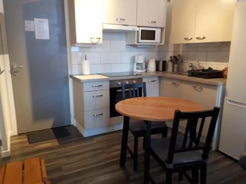 une cuisine avec une table en bois et une petite table et des chaises dans l'établissement Appartement confortable face à la montagne, à Aime La Plagne