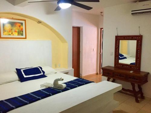 a bedroom with a bed and a mirror at Villa Palmitas acogedor departamento nivel piscina gigante jardines in Acapulco