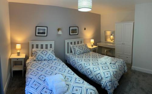 two beds sitting next to each other in a bedroom at Causeway Coast Apartments Cora Marine in Ballycastle