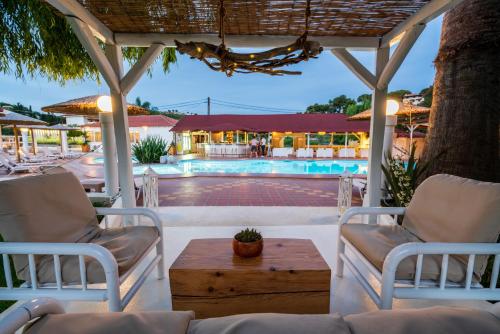 a patio with chairs and a table and a pool at Almira Hotel in Troulos