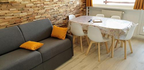 une salle à manger avec une table et un canapé dans l'établissement Triplex E12 Résidence Les Lauzes - Les Menuires - Croisette, aux Menuires