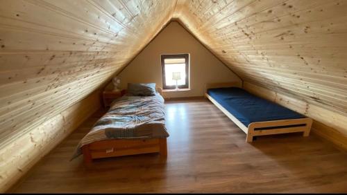 a bedroom with two beds in a attic at Apartamenty Pod Skałą in Hoczew
