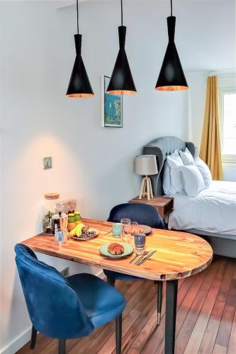 une pièce avec une table, des chaises et un lit dans l'établissement La suite d'Etretat, à Étretat