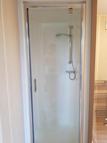 a shower with a glass door in a bathroom at De Bijsselse Enk, chalet 20 A in Nunspeet
