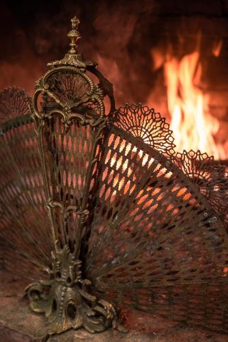 a metal fan sitting in front of a fire at Linaje Hotel Boutique & Relax in Lago Puelo