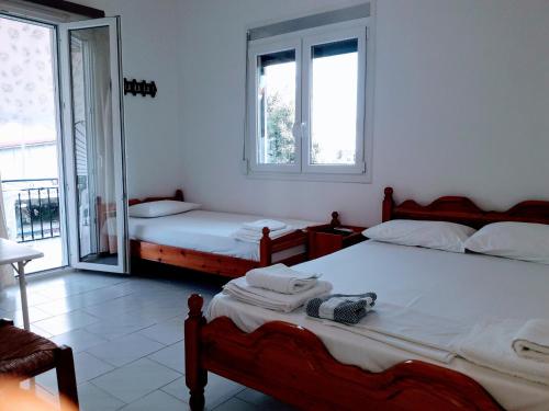 a bedroom with two beds and two windows at Giannis Studios in Nikiana