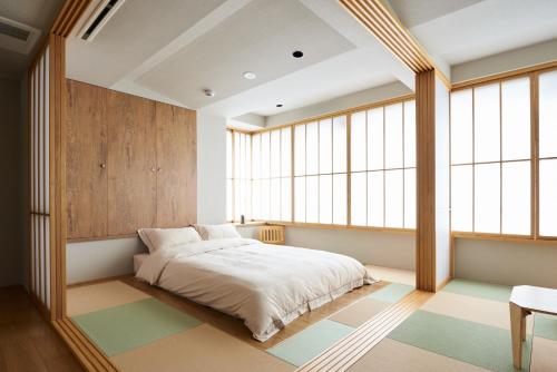 1 dormitorio con 1 cama en una habitación con ventanas en Only Cool Stay - Vacation STAY 26939v, en Tokio