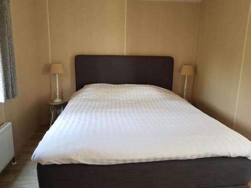 ヌンスペートにあるDe Bijsselse Enk, chalet 20 Aのベッドルーム(白いシーツを使用した大型ベッド1台付)