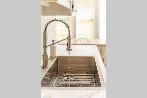 a kitchen sink with water coming out of it at ⋘ Hidden Retreat 12min to UF or Downtown Gainesville and 30min to the Springs ⋙ in Gainesville