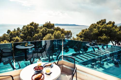 a balcony with a table and a view of the ocean at City Beach Makarska in Makarska