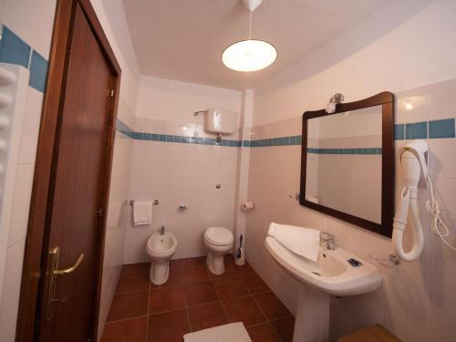 a bathroom with a sink and a toilet and a mirror at AFFITTA CAMERE CASA DELLE ROSE in Villanova Monteleone