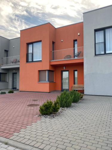 une maison orange avec une allée en briques devant elle dans l'établissement Kotedžas Šventojoje, à Palanga