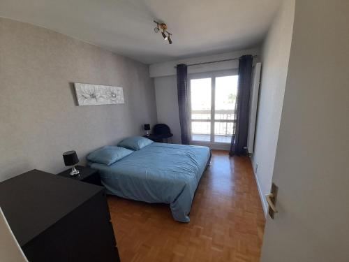 une chambre avec un lit bleu et une fenêtre dans l'établissement Appartement Hyper centre avec garage, à Saint-Étienne