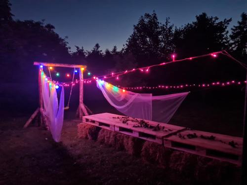 a tent with lights and a table in the dark at Siedlisko Józefka in Zaróbka