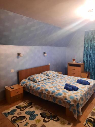 um quarto com uma cama com paredes azuis e cortinas azuis em Pensiunea Ana-Maria em Polovragi