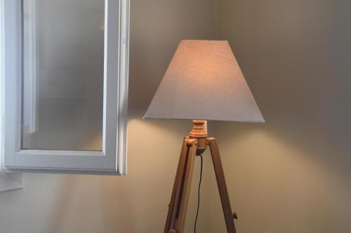 a lamp sitting next to a wall with a mirror at Laurel house in Triandáros