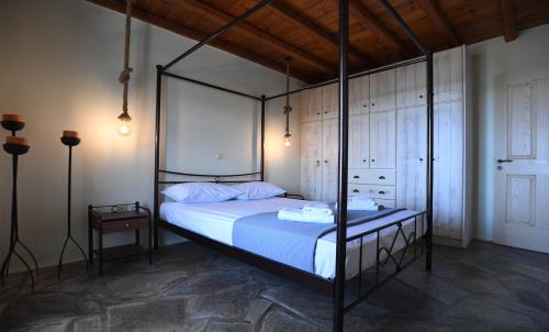 a bedroom with a canopy bed with blue sheets at Laurel house in Triandáros
