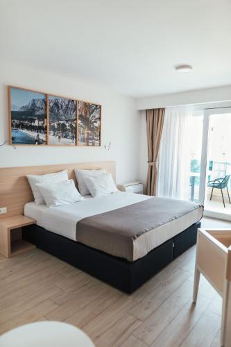 a bedroom with a large bed and a large window at City Beach Makarska in Makarska