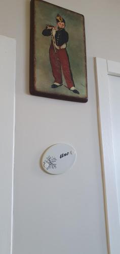 a picture of a man hanging on a wall with a frisbee at Hôtel restaurant du Commerce in Poulainville